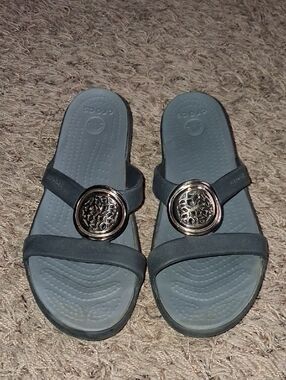 Women's Grey / Black Slide Sandals with Decorative Gold Medallion Crocs Size 8